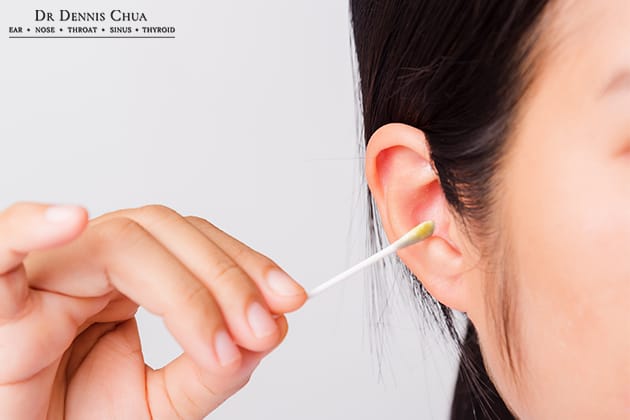woman using cotton buds for earwax