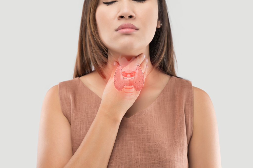 Woman in a brown top holding her neck, with an illustration of a thyroid gland overlaying her throat