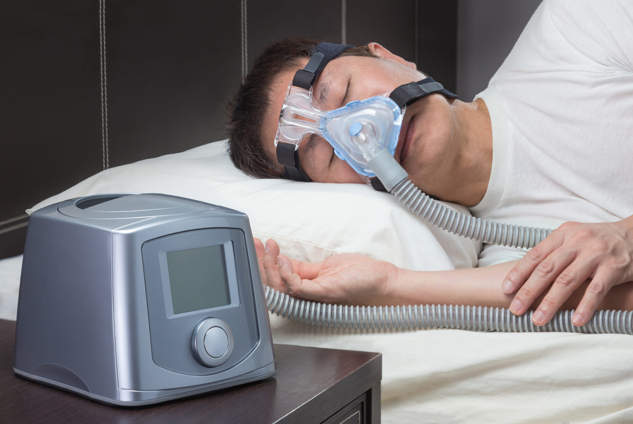 asian man with sleep apnea using cpap machine