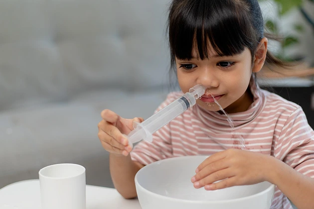 Child using a nasal saline rinse for allergy relief.