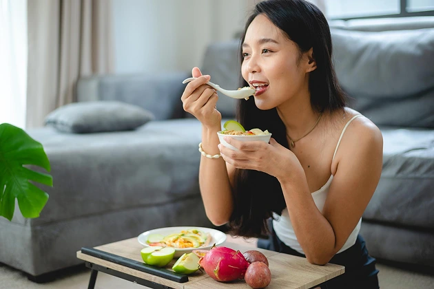 Young woman eating fresh fruit for allergy management